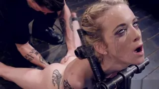 Blonde has head locked in wooden box