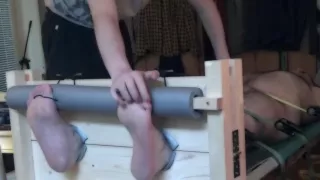 Naked bear tickled in stocks and on a rack