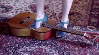 Girl crushing a guitar in high heels