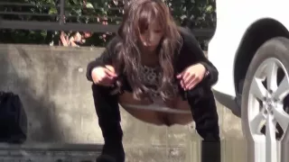 Asian pisses behind car
