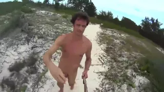 Harter nackter Kerl läuft am Strand herum