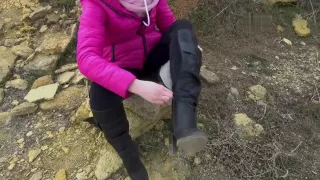 Girl sprains her ankle in high heeled knee boots on beach, bandages ankle