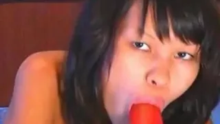 Asian hottie sucking a massive dildo