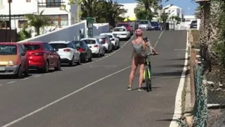 Nackt auf einem Fahrrad durch eine Stadt