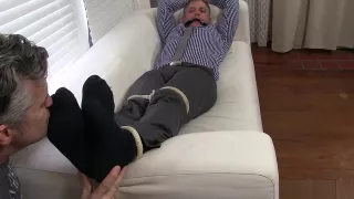 Aged yuppie Brendan Cage is restrained and foot worshipped