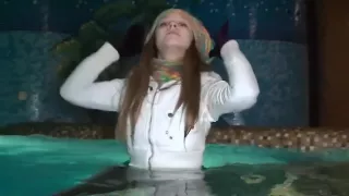 Wet girl in swimming in pool in sexy full clothes