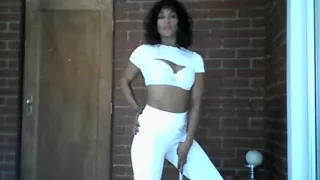 Sia in all white dancing, doing hair and playing with weights