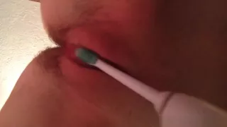 Pushing a toothbrush in her pussy and stimulating a clit