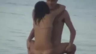 Couple Fools Around in the Water on a Public Beach