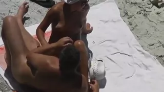 Women gives handjob to her man till he cums at the beach