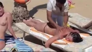 Three girls in swim suits taking a shower at the beach