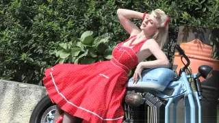 Cute blonde enjoys posing next to a bike