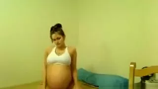 Junges schwangeres Mädchen macht einen Striptease