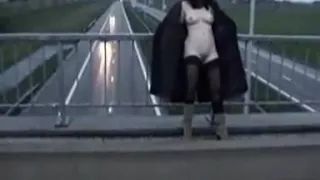 Exhibitionist wife in stockings and long coat flashing motorists on a bridge