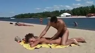 Girl at nudist beach stripping off her clothes and smothered with cream