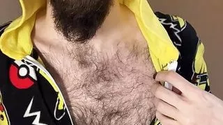 Glatzköpfiger, bärtiger, blauäugiger, weißer Otter in süßem Schlafanzug zieht sich aus, um seinen haarigen Hintern mit einem Gaming-Controller zu necken