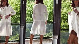 Shemale posiert in einem durchsichtigen Kleid und Nylonstrümpfen