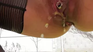 MILF in stockings and heels with a leather skirt pee squatting outside close up on her pierced cunt