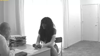 Slim ebony comes to office and kneels on desk