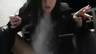 Hot and sexy Dominatrix Nika is smoking a cigarette on her balcony, blowing smoke in your face.