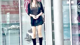 Crossdresser TGirl in kurzem Rock und Stiefeln draußen