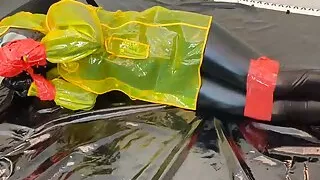 Fejira com Dressed in a yellow plastic raincoat tied with tape