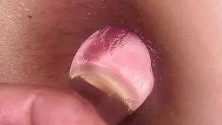 Inserting her butt plug