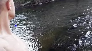 Handsome guy takes bath in a river