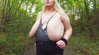 Busty MILF running in the woods