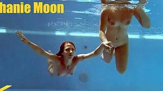 In the indoor pool, two stunning girls swim