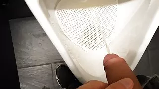 Young boy pissing in public toilet