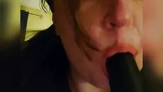 Sucking a big black dildo