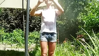 Alexa Cosmic trans girl wetting & wetlook in the garden in white t-shirt and denim shorts under water from a hose...