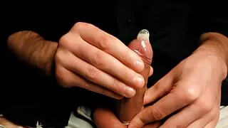 Handsome man Noel Dero masturbates his small cock close-up and cums in a condom.