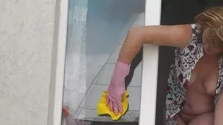 MILF in bathrobe without panties and bra washes window of apartment. Nude in public. Naked in public. Big natural tits MILF