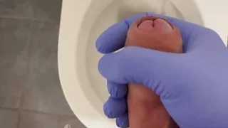 Jerking doctor at a toilet with latex gloves