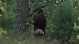 Lustful brunette undresses in the woods and walks naked