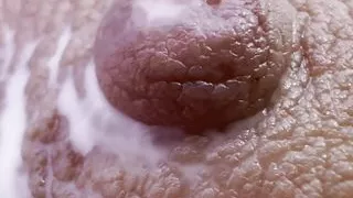 Mother milks her big nipple full of milk