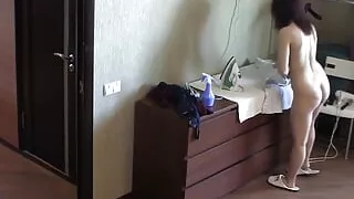Petite dame ironing her clothes nude in the house