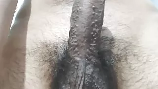 Boy masturbating and doing cock massage in standing position dim light