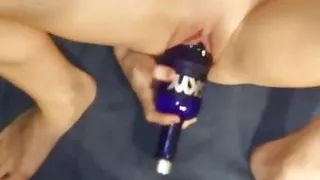 Skinny slut fucks a vodka bottle leaving her gaping pussy wide open