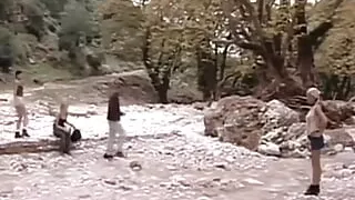 Beautiful brunette fucks a man by a creek