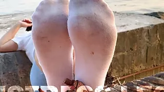 Goddess feet in dirty white socks closeup against sea sunset
