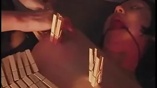 BDSM bitch drips hot wax on petite bondaged Asian with red ball in mouth