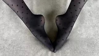 Girl in black nylon tights caresses her legs in different poses