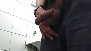 Mature massaging dick in the bathroom at work