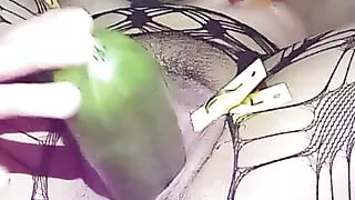 Stretched vaginal lips inserting a big cucumber and squirting