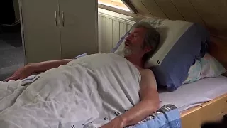 Schwarzhaarige Krankenschwester kümmert sich um ihren alten Patienten