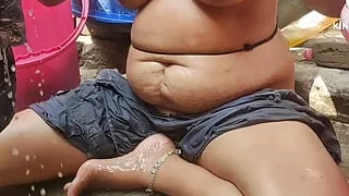 Indian  house wife bathing outside and washing