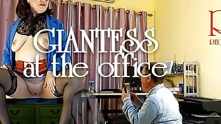 A giant secretary sits on an office desk. The manager guy is very surprised at her height.